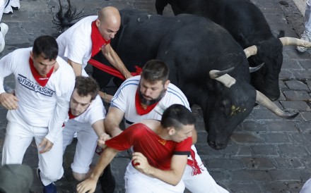 Runners are chased by bulls from the Jandilla ranch during the final run of the San Fermin festival in Pamplona on Tuesday. Photo:   EPA