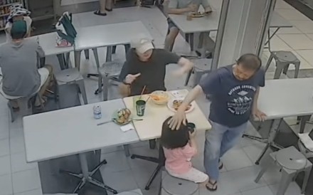 A 73-year-old man, Yeo Song Khoon, is seen patting a girl’s head at a food court in Roxy Square in Singapore on Saturday. Photo: Instagram/being1ton
                                