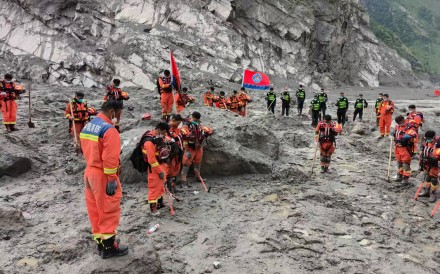 Rescuers observe a moment of silence for the victims of the mudslide in Gyirong county, Tibet. Photo: AP