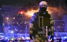 A Russian soldier secures the area as a massive blaze burns in the Crocus City Hall concert venue on March 22 following a deadly attack claimed by Isis. Photo: AP