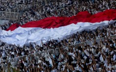 The Indonesian flag being held aloft during a campaign rally in Jakarta. Photo: EPA