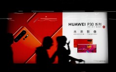 Commuters pass a Huawei P30 smartphone advertisement inside a Beijing subway station. Photo: AP