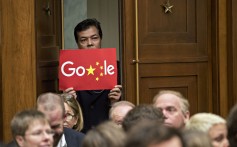 A man holds up a sign featuring an altered Google logo during a House Judiciary Committee hearing with Google CEO Sundar Pichai in Washington in December 2018. Photo: Bloomberg