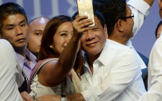 A supporter takes a selfie with Philippine President Rodrigo Duterte. Internet speeds in the country lag the region’s. Photo: AFP