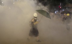 A protester walks through billowing tear gas outside a train station in Wong Tai Sin on August 4, 2019. Photo: Sam Tsang
