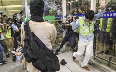 A police officer (right) draws and points his gun at the airport. Photo: Felix Wong