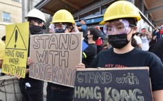 Pro-Hong Kong supporters hold signs during a rally at the Broadway-City Hall SkyTrain Station in Vancouver. Photo: AFP