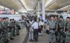 Police stand guard at Hong Kong airport on Saturday. Photo: Sam Tsang