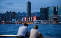 Two friends chat in front of Victoria Harbour. Photo Agence France-Presse