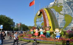 People pass by a flower bed titled “Community with a Shared Future” in Beijing on September 24, one of 12 such beds built along Changan Avenue to celebrate the 70th anniversary of the founding of the People's Republic of China. Photo: Xinhua