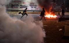 Indonesian students set items on fire as police shoot tear gas in Jakarta on Monday. Photo: AFP