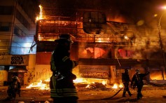 Firemen work to put out fire at a supermarket during a protest against the government in Chile. Photo: Reuters