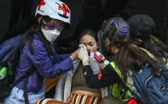 First aiders treat a woman affected by tear gas during anti-government protests in Central, Hong Kong. Photo: K.Y. Cheng