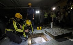 Firefighters look down a manhole to see whether any protesters have tried to escape through it. Photo: Felix Wong