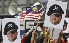 Protesters demonstrating against alleged corruption at 1MDB with portraits of Jho Low in Kuala Lumpur, Malaysia. Photo: AP