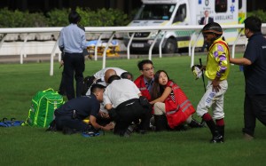 Karis Teetan (right) limps away from Wednesday night’s horror Happy Valley fall, while Jerry Chau is treated on the track. Photo: Kenneth Chan