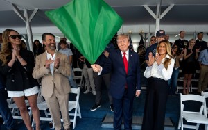 US President Donald Trump waves the green flag to start the race alongside First Lady Melania Trump, right, and from left, Bettina Trump and Donald Trump Jnr during the IndyCar Freedom 250 Grand Prix on Sunday in Washington. Photo: The New York Times via AP / Pool