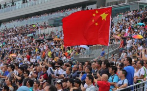 A fan raises a Chinese flag at Sha Tin’s season opening meeting on Sunday. Photos: Kenneth Chan