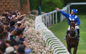 Hugh Bowman throws his goggles into the crowd after winning the 2015 Cox Plate with Winx. Photo: Michael Dodge/Getty Images