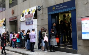 Gamblers line up at a Hong Kong Jockey Club off-course betting branch in Central. Photo: SCMP/Dickson Lee