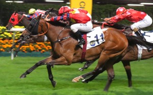 Matthew Poon drives Travel Datuk over the line at Happy Valley on Wednesday night. Photos: Kenneth Chan