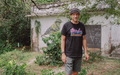 Dominic Johnson-Hill in front of a mural featuring a yellow-browed warbler in Mui Wo, Lantau Island. Photo: Jocelyn Tam