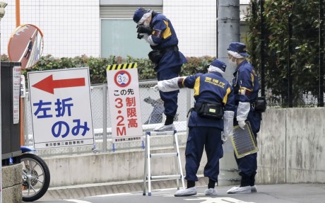 Japanese police investigators work near the scene of a stabbing of a woman in the Shinjuku district of Tokyo on March 11. Photo: Kyodo/AP