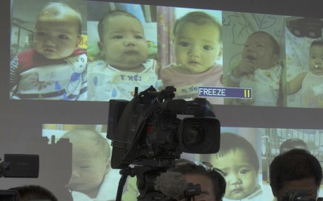Media attend a press briefing where Thai police showed pictures of surrogate babies in 2014, the year before Thailand banned commercial surrogacy. Photo: AP