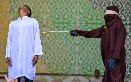A man convicted of having sex outside marriage receives 100 lashes from a member of the sharia police during a public caning in Banda Aceh, Indonesia, on May 21. Photo: AFP