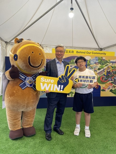 Club Steward Dr Silas Yang (centre) takes a photo at the Jockey Club booth with beneficiaries of the Jockey Club Volleyball Community Programmes.