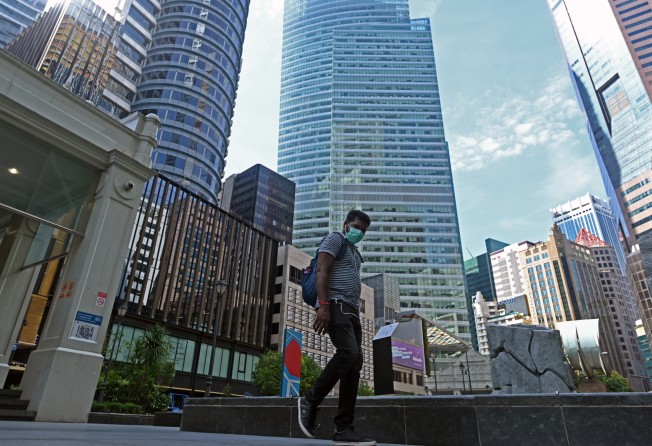 A man walks next to commercial buildings in the Raffles Place financial business district in Singapore in April 2020. Photo: AFP