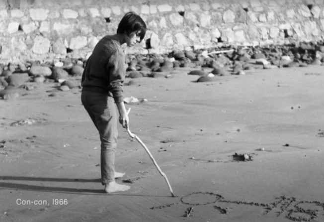 Vicuña draws in the sand on a beach in Chile in 1966. Photo: Courtesy of Cecilia Vicuña 
