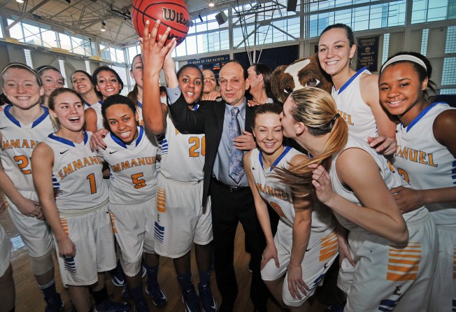 Emmanuel College head coach Andy Yosinoff (centre) hoists the game ball along with his team after they defeated Lasell College for Yosinoff’s 700 career win on January 26, 2013. Photo: Getty Images