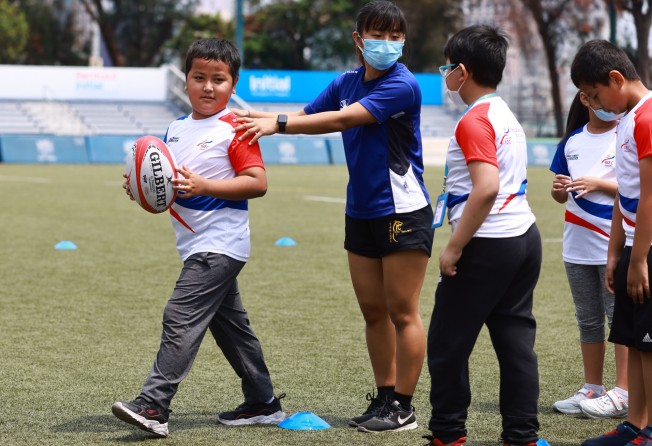 HKRU coaches teaching IBEL children some simple rugby drills at King’s Park rugby pitches in Jordan. Photo: SCMP/May Tse 