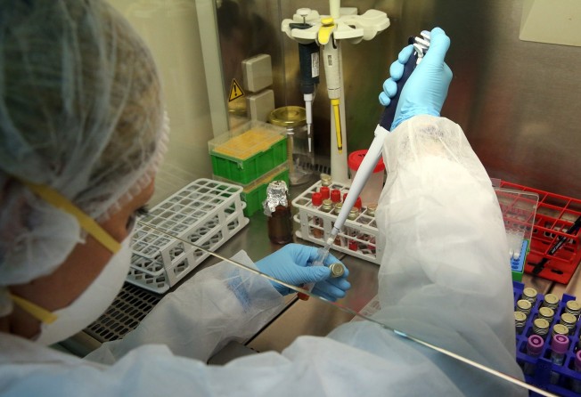 A microbiologist performs tests to detect the presence of the novel Sars-CoV-2 coronavirus at a biosafety laboratory in Greece in April last year. Photo: EPA