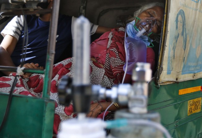 A Covid-19 patient receives oxygen inside an auto rickshaw in Ahmedabad, India. Photo: AP