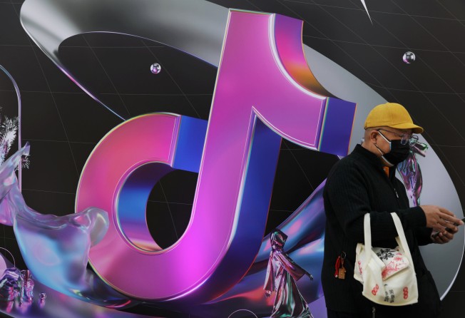 A man stands near a giant sign of Chinese company ByteDance’s app TikTok, known locally as Douyin, during China Fashion Week, 2021. Photo: Reuters 