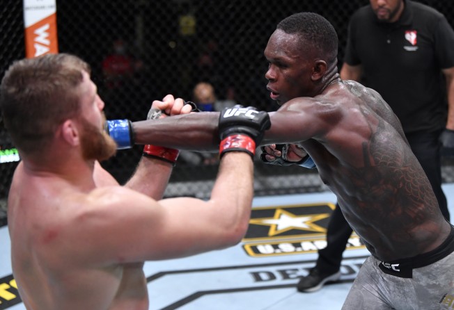 Israel Adesanya punches Jan Blachowicz in their light heavyweight championship fight at UFC 259.