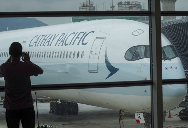 A traveller takes a picture of a Cathay Pacific A350-1000 aircraft parked at Hong Kong International Airport. Photo: Roy Issa