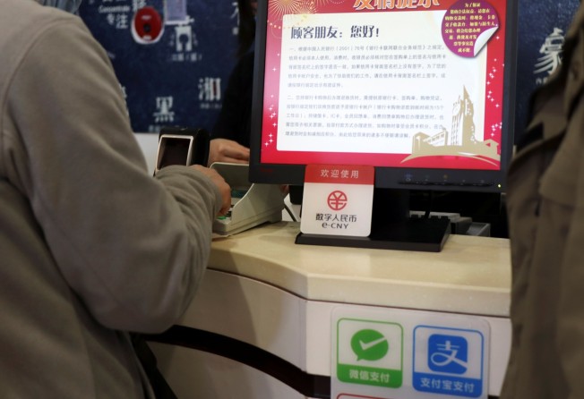 A sign of China’s digital yuan, or e-CNY, is seen above WeChat Pay and Alipay signs at a counter during a trial of the Digital Currency Electronic Payment (DCEP) at a shopping centre in Beijing, China, on February 10, 2021. Photo: Reuters