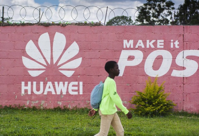A pedestrian passes by a Huawei mural painted on a wall in Zambia. Photo: Bloomberg