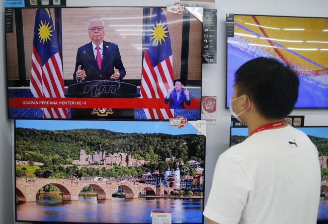 A shop worker watches a speech by Malaysia’s new Prime Minister Ismail Sabri Yaakob on television in Shah Alam. Photo: AP
