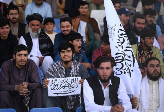 Spectators hold Taliban flags as they watch a cricket match in Kabul on September 3. Photo: AFP