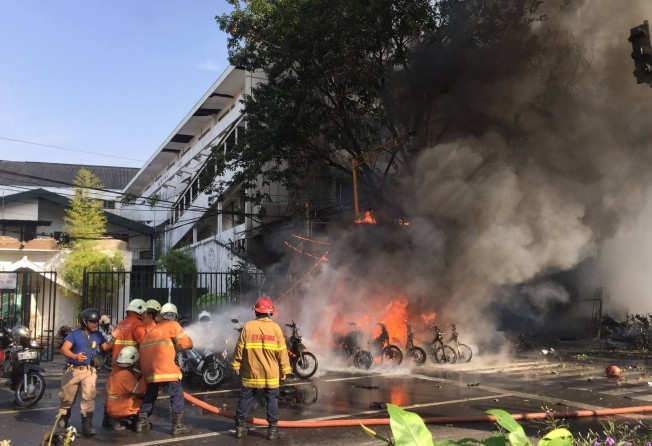 Firefighters try to extinguish a fire after a blast outside a church in Surabaya on May 13, 2018. Photo: AFP