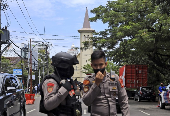 Police officers stand guard near a church where an explosion went off in Makassar, South Sulawesi, Indonesia on March 28, 2021. Photo: AP