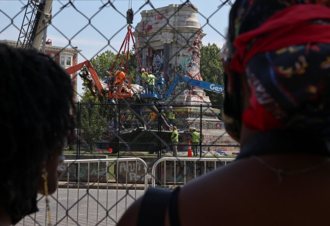 People watch as the statue of Confederate General Robert E. Lee, the largest Confederate statue that remained in the United States, is removed by a construction team in Richmond, Virginia, on September 8. Photo: Reuters