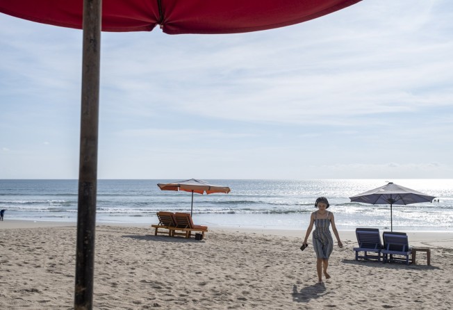 A tourist at Kuta beach in Bali, Indonesia. Quarantine for fully vaccinated visitors has been cut to just three days. Photo: EPA