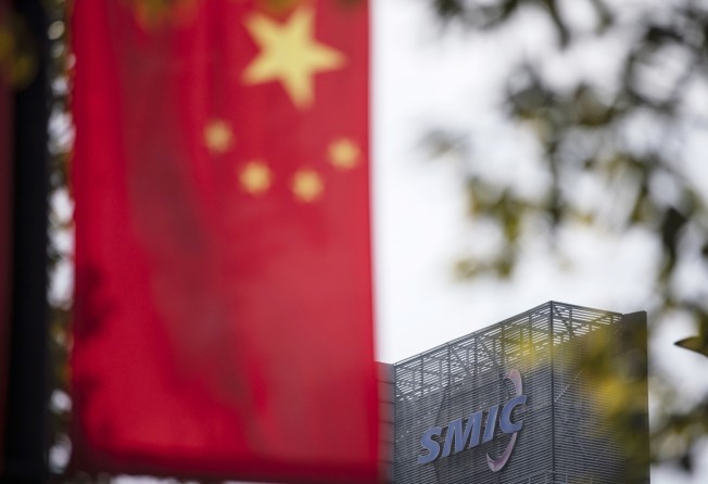 A Chinese flag near a logo atop the Semiconductor Manufacturing International Corp. (SMIC) headquarters in Shanghai, China, on Tuesday, March 23, 2021. Photo: Bloomberg