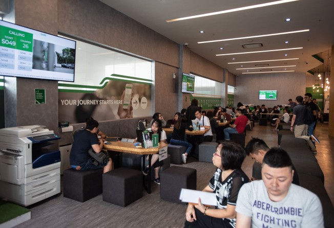 Drivers wait their turn to be served by customer service agents at Grab’s driver centre in Singapore. Photo: SCMP