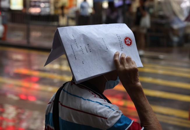 A man with an iBond prospectus during a thunderstorm in Mong Kok on 1June 2021. Photo: Nora Tam